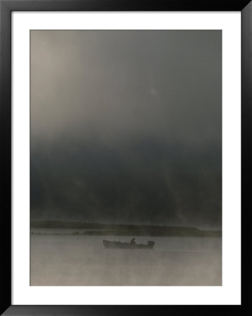 On A Stormy Evening, A Lone Boater Floats Beneath An Ominous Sky by Sam Kittner Pricing Limited Edition Print image