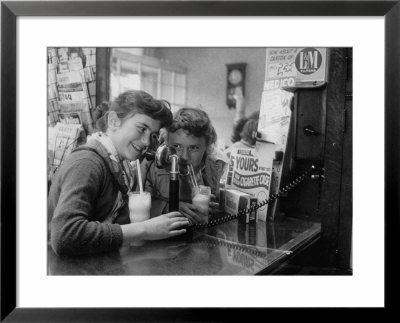 Teenage Girls Drinking Milkshakes At A Local Restaurant by Francis Miller Pricing Limited Edition Print image