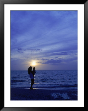 Silhouette Of Mother And Child On Beach At Sunset by Greg Smith Pricing Limited Edition Print image
