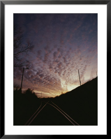 Clouds At Twilight Create Purple And Pink Streaks Across The Sky by Sam Kittner Pricing Limited Edition Print image