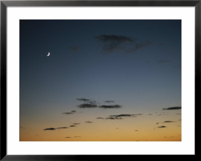 A Crescent Moon Rises Above The Ocean Shortly After Sunset by Todd Gipstein Pricing Limited Edition Print image