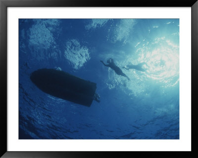 Underwater View Of Swimmers And A Boat At The Surface Of The Ocean by Randy Olson Pricing Limited Edition Print image