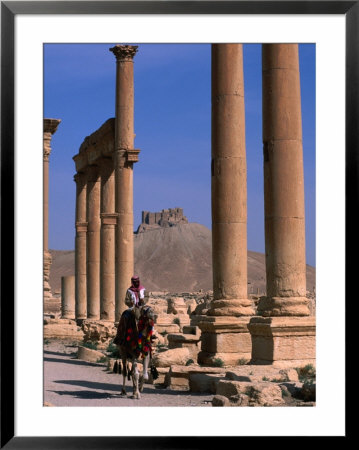 Rider On Camel Walking Along The Colonnaded Street Of Ruins, Palmyra, Syria by John Elk Iii Pricing Limited Edition Print image