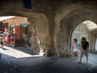 People Walking Through Entrance To Saint-Paul De France, Cote D'azure, France by Robert Eighmie Pricing Limited Edition Print image