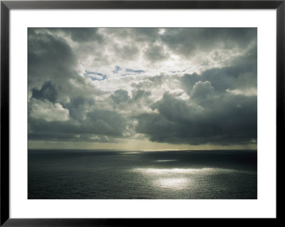 Sunlight Shines Through Dark Clouds Onto The Seas Surface by Joel Sartore Pricing Limited Edition Print image