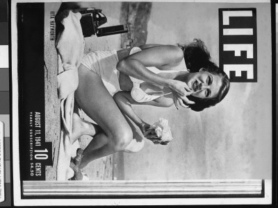 Life Cover Featuring Rita Hayworth Eating A Hamburger, Sunbathing In A White Swimsuit At The Beach by Bob Landry Pricing Limited Edition Print image