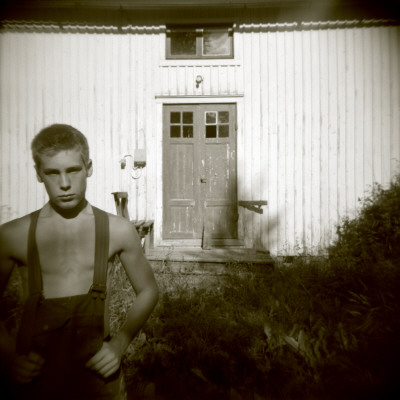 Portrait Of A Teenage Boy Standing In Front Of An Abandoned House, Boden, Norrbotten, Sweden by Inger Bladh Pricing Limited Edition Print image