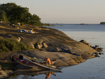 High Angle View Of A Man Sitting Near Kayaks At The Coast, Sweden by Bjorn Wiklander Pricing Limited Edition Print image