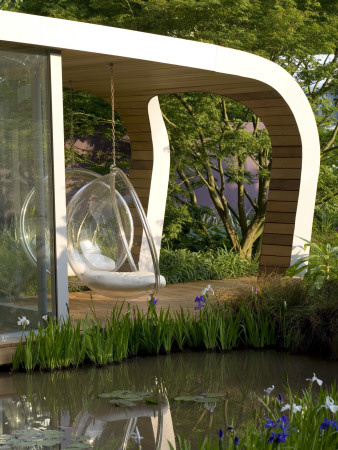 Pavillion Clad In Cedar Wood With Bubble Chair And Recycled Timber Decking Overlooking Pond by Clive Nichols Pricing Limited Edition Print image