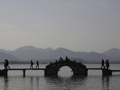 People Crossing A Bridge Over A Lake In Twilight, China by Ryan Ross Pricing Limited Edition Print image
