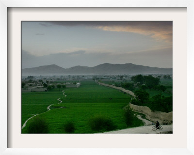 An Afghan Man Rides His Bicycle On A Dirt Road On The Northern Edge Of Kabul, Afghanistan by David Guttenfelder Pricing Limited Edition Print image