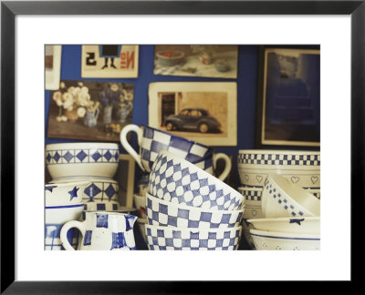 Blue And White Crockery In Front Of Wall With Photographs by Michael Paul Pricing Limited Edition Print image