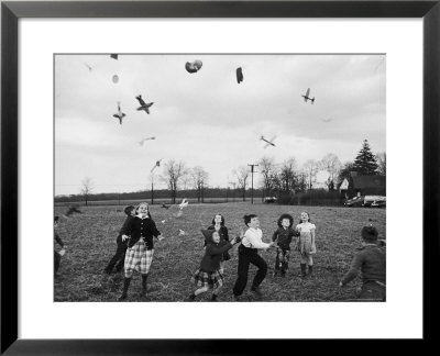Children Trying To Catch Toys That Were Released By A Kite In The Air by Bernard Hoffman Pricing Limited Edition Print image