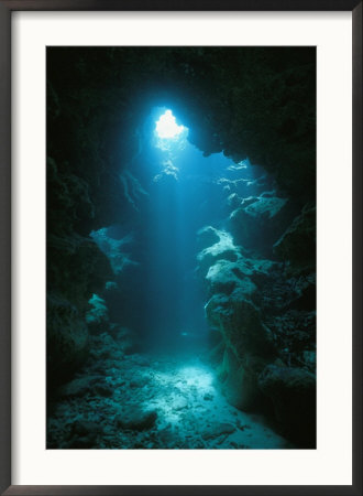 A Beam Of Sunlight Illuminates An Underwater Cave by Raul Touzon Pricing Limited Edition Print image
