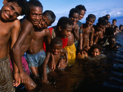 Children Playing In Water, Manam Island, Madang, Papua New Guinea by Jerry Galea Pricing Limited Edition Print image