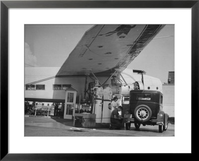 Service Attendant Pumping Gasoline Into Ford Sedan As Woman Watches At Gas Pumps by Peter Stackpole Pricing Limited Edition Print image