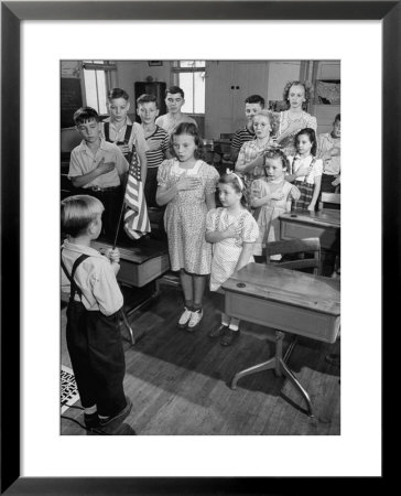 Children Reciting The Pledge Of Allegiance As A Boy Holds The Us Flag In Their Classroom by Bernard Hoffman Pricing Limited Edition Print image