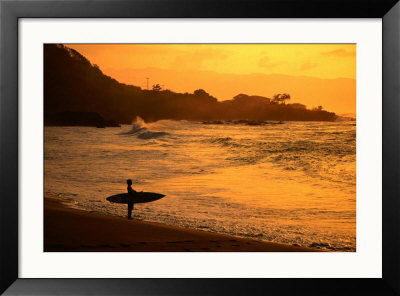 Surfer Standing At Waimea Bay At Sunset, Waimea, U.S.A. by Ann Cecil Pricing Limited Edition Print image