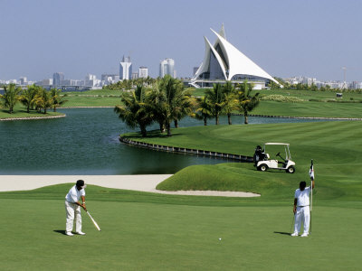 Men On Dubai Creek Golf With Yacht Club In Distance, Dubai, United Arab Emirates by Holger Leue Pricing Limited Edition Print image