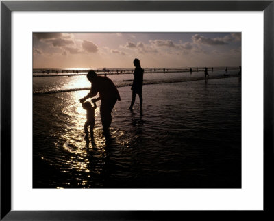 Families Play In A Shallow Lagoon At Sunset by Michael Nichols Pricing Limited Edition Print image