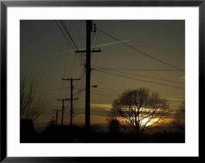 Row Of Telephone Poles With Jet Contrails And Sunset In The Distance by Todd Gipstein Pricing Limited Edition Print image