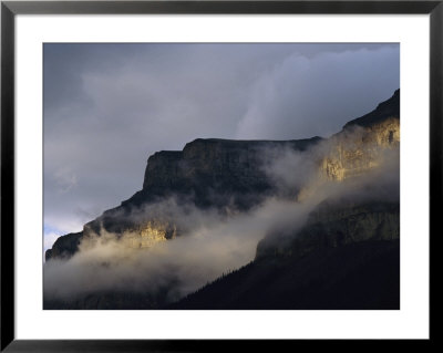 A Mountain Peaks Through The Clouds In Banff National Park by Stephen Alvarez Pricing Limited Edition Print image