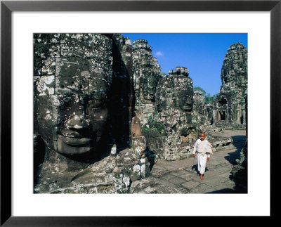 Buddhist Nun Walking Amongst Massive Stone Faces In Temple Grounds Of Bayon, Angkor Thom, Cambodia by Bill Wassman Pricing Limited Edition Print image