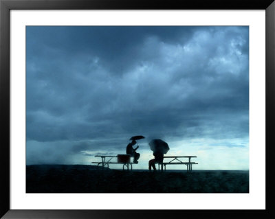 Tourists Sit On Picnic Tables While Waiting Out A Storm by Raymond Gehman Pricing Limited Edition Print image