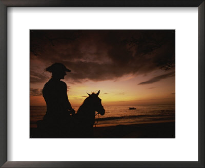 Horseback Rider Silhouetted On A Beach At Sunset, Costa Rica by Michael Melford Pricing Limited Edition Print image
