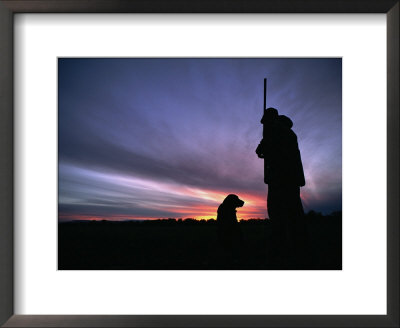 A Silhouetted Hunter And His Dog At Twilight by Gordon Wiltsie Pricing Limited Edition Print image