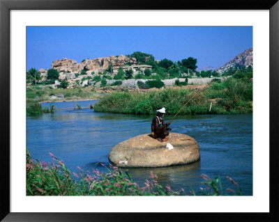 Fisherman On Rock In Tungabhadra River, Hampi, India by Peter Ptschelinzew Pricing Limited Edition Print image