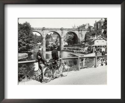 Two Cyclists Take A Break On A Bridge Over The River Nidd At Knaresborough by Fred Musto Pricing Limited Edition Print image