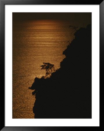 A Cinque Terre Cliffside Silhouetted Against The Sun-Reflected Sea by Raul Touzon Pricing Limited Edition Print image