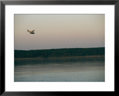 A Seaplane Soars Above The Mackenzie River At Dusk by Raymond Gehman Pricing Limited Edition Print image