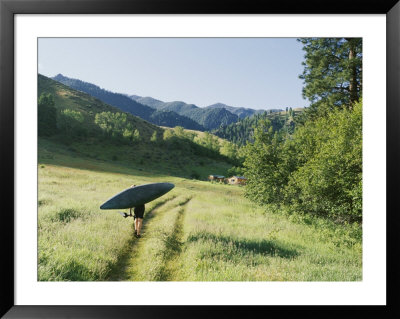 A Woman Portages A Kayak Along A Trail by Skip Brown Pricing Limited Edition Print image