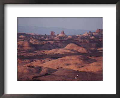 A Cyclist Riding Through Hilly Terrain by Joel Sartore Pricing Limited Edition Print image