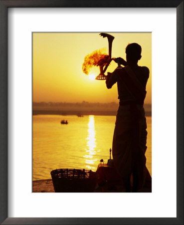 Priest Moves Lantern In Front Of Sun During Morning Puja On Ganga Ma, Varanasi, India by Anthony Plummer Pricing Limited Edition Print image