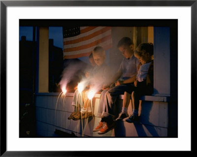 Boys Sitting On Porch Holding Sparklers, With Us Flag In Back, During Independence Day Celebration by Nat Farbman Pricing Limited Edition Print image