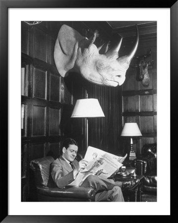 Member Reading Newspaper In Smoking Room At The Harvard Club Beneath A Rhino Head Trophy by Alfred Eisenstaedt Pricing Limited Edition Print image