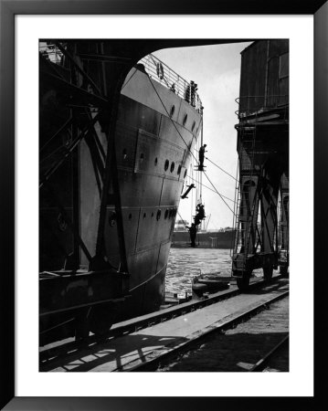 Workers Hanging From Hull Of Ship In Hamburg Harbor, In The Midst Of Painting It by E O Hoppe Pricing Limited Edition Print image