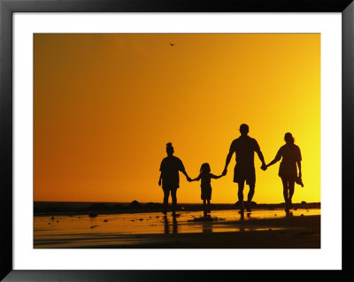 A Family Holding Hands Is Silhouetted Against The Setting Sun by Rich Reid Pricing Limited Edition Print image