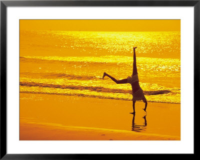 Girl Doing Cartwheels On Beach At Sunset by Jennifer Broadus Pricing Limited Edition Print image