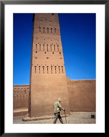 Man Walking Past Minaret, Part Of Oulad Driss Kasbah, Near M'hamid, M'hamid, Morocco by Damien Simonis Pricing Limited Edition Print image