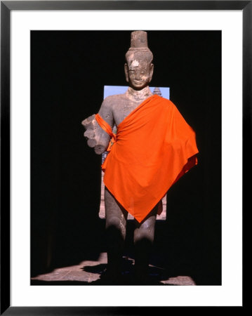 Standing Buddha Statue In Orange Cloth, In Outer Gallery At Angkor Wat, Angkor, Cambodia by Tom Cockrem Pricing Limited Edition Print image