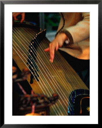 Student Playing Gu Zheng (Chinese Zither) In Shop In Xuanwu (Qianmen) Bejing, China by Phil Weymouth Pricing Limited Edition Print image