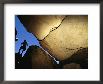 A Silhouetted Climber Surveys Indian Pictographs Inscribed Upon A Rock by Bill Hatcher Pricing Limited Edition Print image