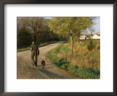 A Man And Dog Walk Along The Road Near Historic Stevens Creek Farm by Joel Sartore Pricing Limited Edition Print image
