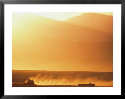 Twilight View Of A Wheat Harvester At Work by Kenneth Garrett Pricing Limited Edition Print image