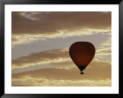 A Soaring Hot Air Balloon Against A Cloud-Filled Sky At Dawn by Jason Edwards Pricing Limited Edition Print image
