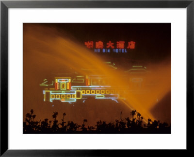 A Hotels Neon Signs Shining Through A Water Fountain At Night by Raymond Gehman Pricing Limited Edition Print image